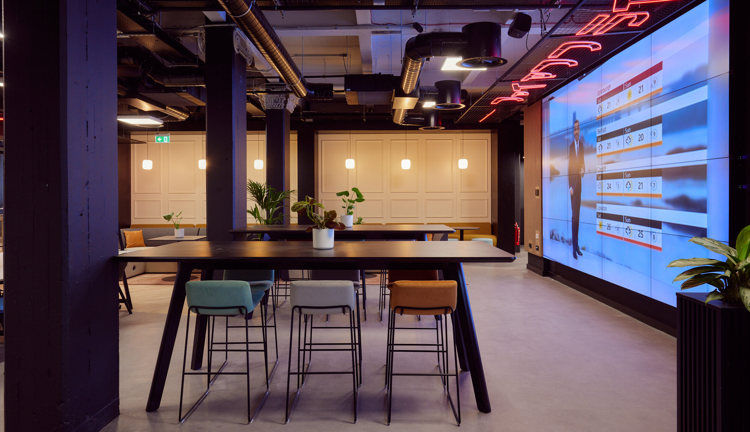 Duke & Parr office space in Liverpool featuring big screen displaying the weather with benches around the room for relaxing